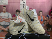 Pair of white Nike Kyrie basketball shoes arranged together, showing black Swooshes and textured detailing.