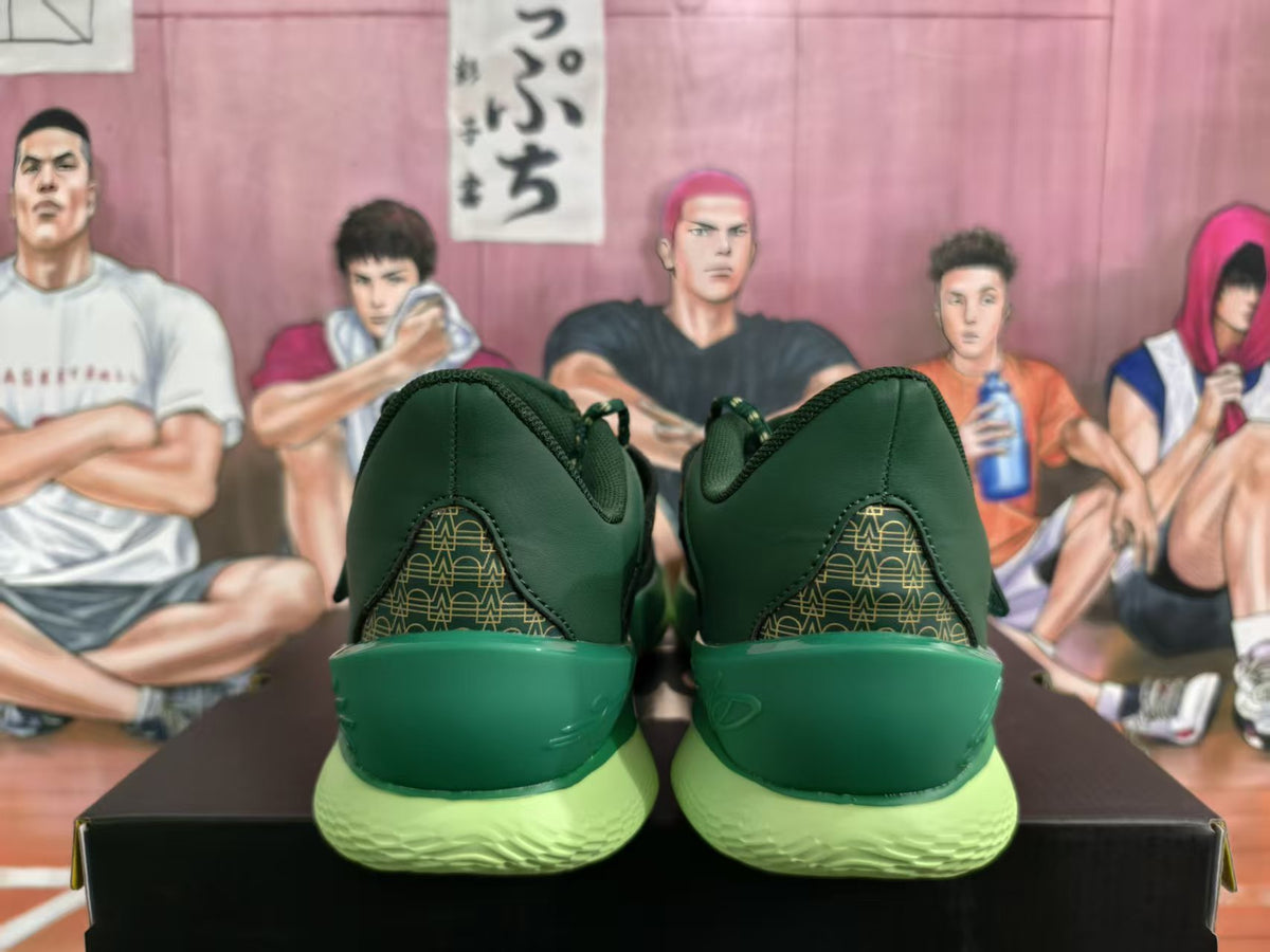 Rear view of green sneakers with gold-patterned heel panels and bright lime-green outsoles on a black shoebox.