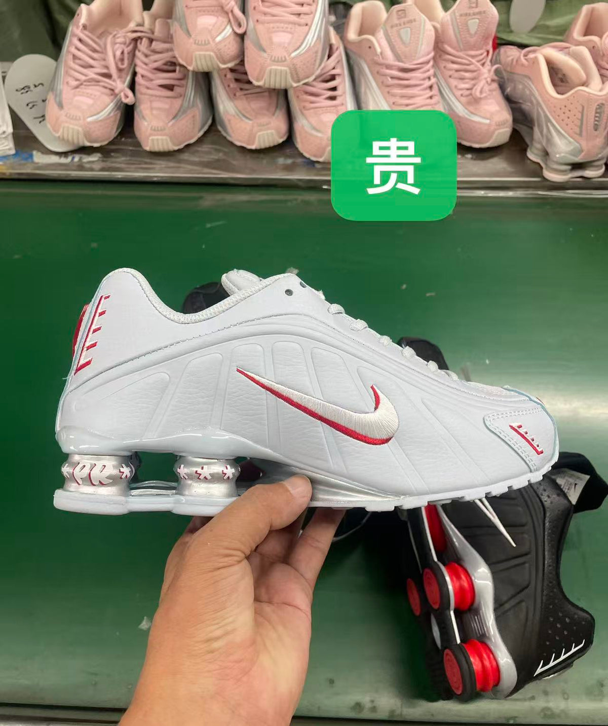Side view of a white Nike sneaker with red-accented Swoosh detailing and spring-like heel columns