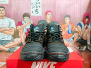 Front view of black and brown high-top sneakers showing laces, layered toe panels, padded tongues, and textured soles.