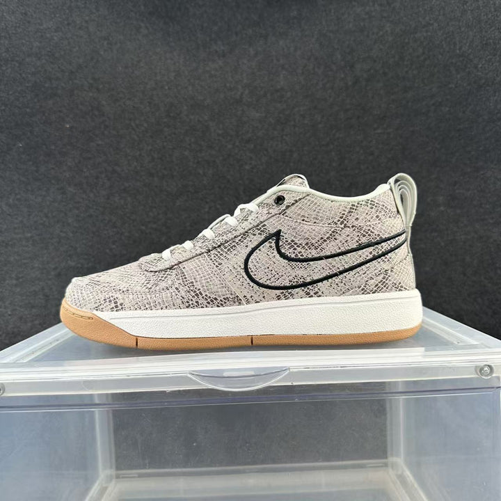 Low-top sneaker with a pale grey snake-print pattern, dark outlined side swoosh, white midsole, and gum-colored outsole