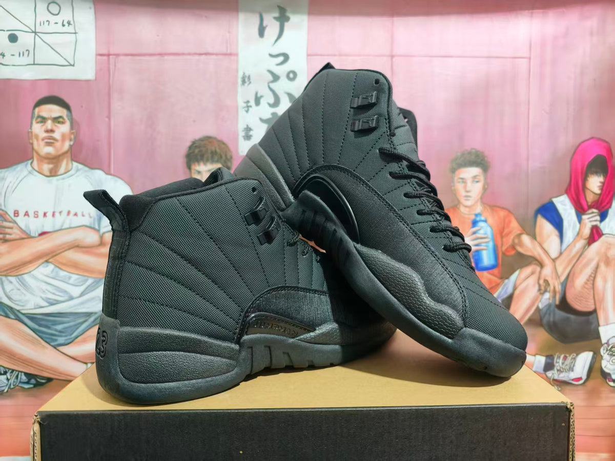 Pair of black Jordan high-top basketball sneakers displayed on a box, showing the side panels, textured outsole, and heel number 23 detail.