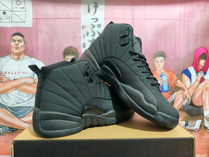 Pair of black Jordan high-top basketball sneakers displayed on a box, showing the side panels, textured outsole, and heel number 23 detail.