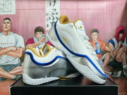 Angled view of the pair showing white uppers, blue trim, silver heel panels, and gold-colored lining.