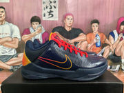 Side view of a navy basketball shoe with a red-and-orange Swoosh and orange-yellow heel accent.