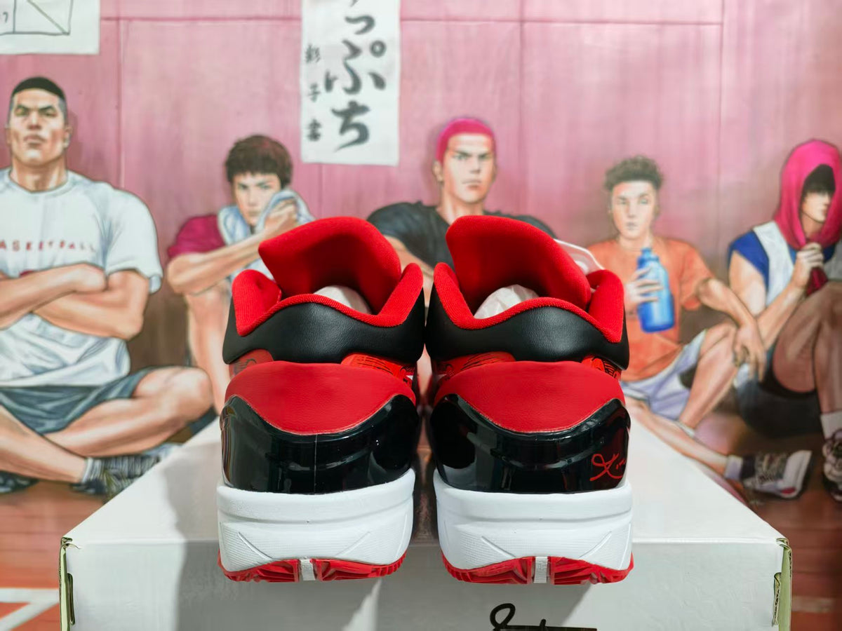 Rear view of red and black basketball sneakers with white midsoles and red outsoles, displayed on a shoebox.