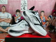 Angled view of the white and black sneakers showing the outsole profile, dotted midsole, Under Armour logo, and visible HOVR lettering.