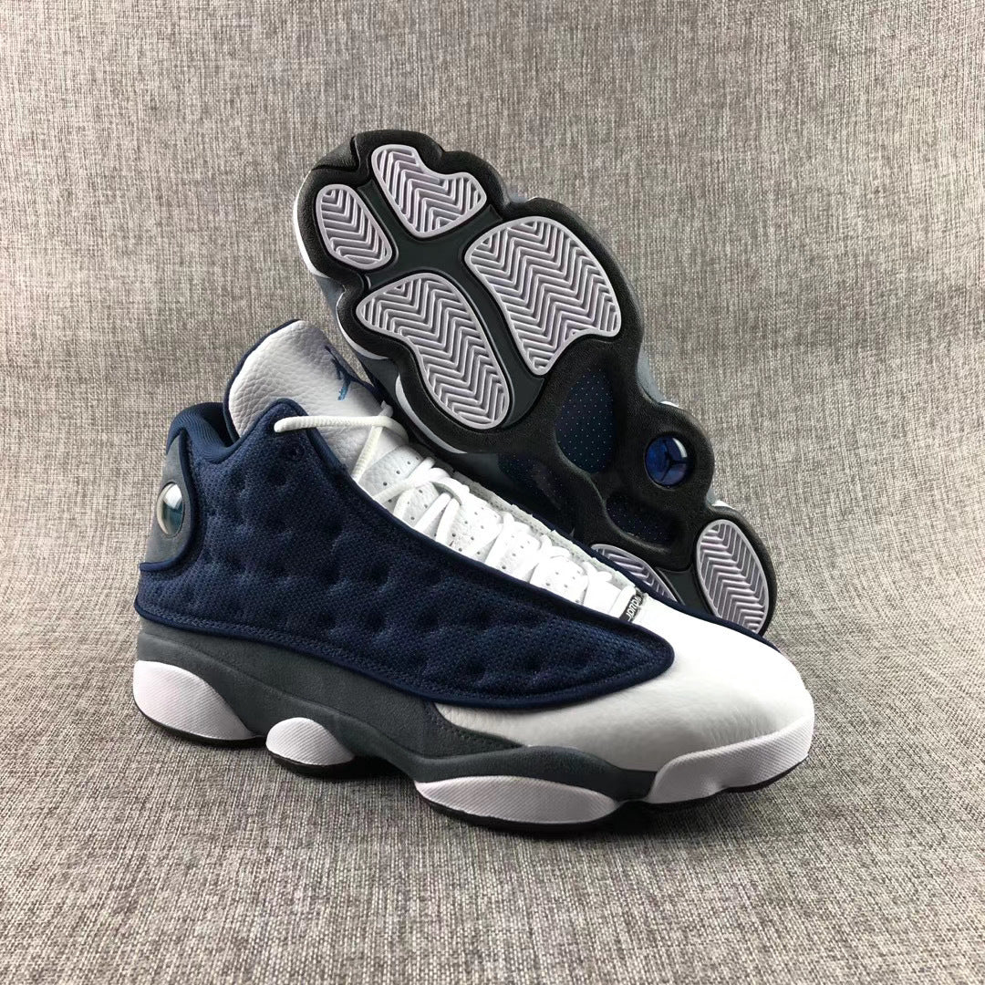Air Jordan 13 Flint sneakers shown with the patterned outsole facing up.