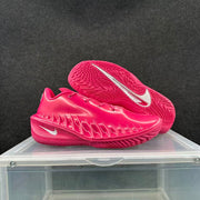 Pair of bright pink basketball sneakers shown from the side and outsole, with white Swoosh branding.