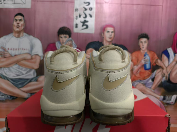 Rear view of beige Nike Air More Uptempo sneakers with Swoosh logos and brown outsole details