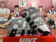 Angled view of white and grey high-top basketball sneakers with burgundy accents