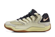 Side profile highlighting the beige midsole, black heel section, mesh-like upper panels, and gum-brown outsole.