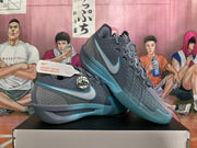 Pair of blue-gray Nike basketball shoes with teal accents, lace-up closure, and visible side Swooshes.