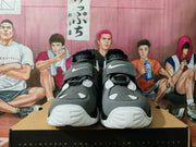 Front view of gray and blue Nike high-top sneakers showing the adjustable straps, tongue details, perforated panels, and white toe soles.