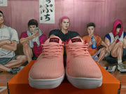 Front view of pink Nike sneakers with pink laces, red collar lining, and red tongue labels.