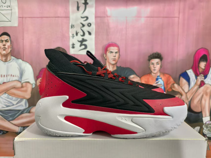 Side view of black and red basketball sneakers resting on a shoebox.