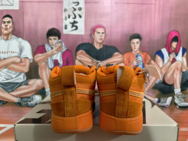 Rear view of orange Nike sneakers showing padded collars, heel panels, and a matching shoe box.