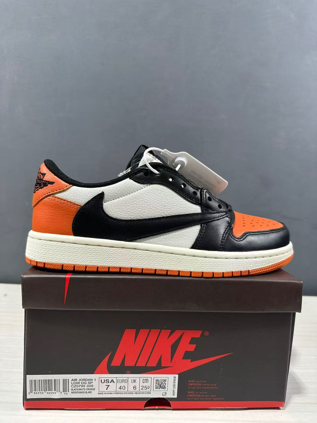 Side view of a black, orange and white Jordan low-top sneaker displayed on a branded shoebox; the box label shows EU 40, US 7, UK 6 and CM 25.