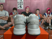 Rear view of white high-top basketball shoes with black-speckled heel overlays.