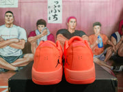 Rear view of the orange sneakers showing heel perforations, padded collars, and black Jumpman branding.