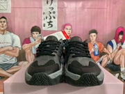 Front view of black and gray PUMA sneakers with textured uppers and patterned soles