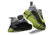 Smoke grey and black sneakers showing the heel and patterned neon outsole.
