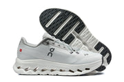 Light gray On running shoe beside a view of its patterned outsole.