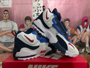 Pair of Nike white, blue, and red strap sneakers displayed on a red Nike shoebox.
