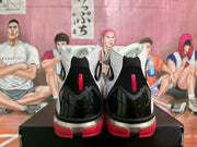 Rear view of the high-top sneakers showing black heel panels, red vertical accents, and red outsole sections.