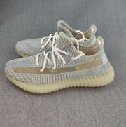Pair of gray and cream Yeezy 350 V2 sneakers arranged in a side-facing view.