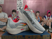 Brooks Hyperion Max shoes shown at an angle, highlighting the side branding and orange-red accents