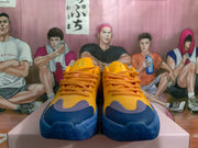Front view of yellow and blue lace-up sneakers with orange laces and contrasting toe panels.
