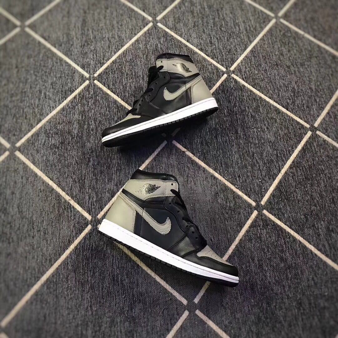 Pair of black and grey high-top sneakers shown from angled side views on a patterned floor.