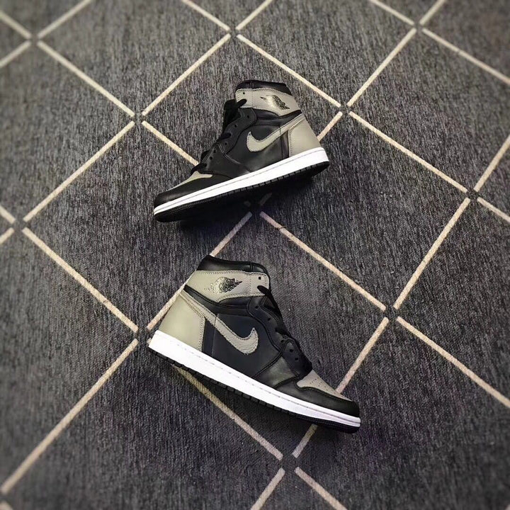 Pair of black and grey high-top sneakers shown from angled side views on a patterned floor.