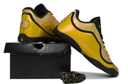 Yellow and black Nike LeBron 23 basketball shoes arranged over a black shoebox with black and gold laces.