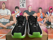 Front view of black lace-up Nike sneakers with white trim and bright green toe outsole sections.