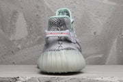Rear view of the sneaker showing the heel pull tab, mint collar trim, and translucent sole.