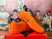 Side view of orange Nike sneakers with gold-tone side logos and blue collar details.