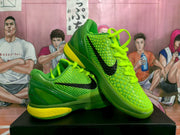 Pair of bright green Nike basketball sneakers with black swooshes and yellow midsole accents, displayed on a black box.