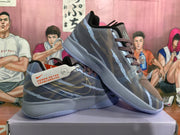 Angled view of the blue-gray sneaker pair showing the patterned sides, brown laces, and light-gray soles.