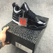 Black sneaker displayed on a patterned shoe box with a decorative hangtag; the box label visibly shows EU size 40.