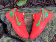 Overhead view of a pair of red Nike Kobe 6 shoes with green accents