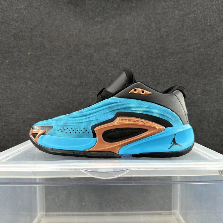 Side view of a blue, black, and bronze Jordan basketball sneaker on a clear display stand