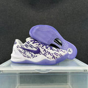 Pair of white and purple Nike basketball sneakers showing the patterned upper, purple Swoosh, laces, and translucent outsole.