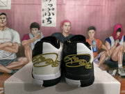 Rear view of black and white Nike basketball sneakers with gold-colored heel detailing on a shoebox.