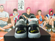 Rear view showing grey heel panels and signature details on the black shoes.