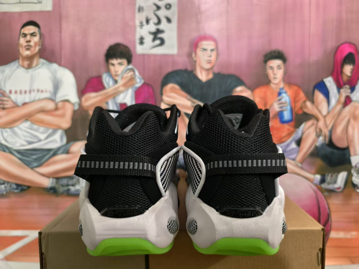 Rear view of black and white Nike sneakers with bright green outsole sections and a patterned heel detail.