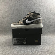 Side view of the sneaker displayed on a black box; the label shows Air Jordan 1 Mid SE (GS), style BQ6931-021, EU 37.5, and 23.5 cm.