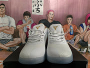 Pair of white Nike basketball sneakers shown from the front, with gold Kobe emblems on the tongues and a translucent outsole.