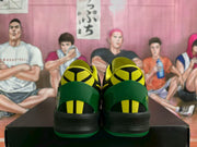 Rear view of the sneaker pair showing green heel panels, yellow and black heel details, and black midsoles.